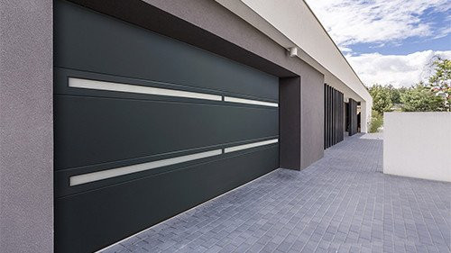 Stijlvolle brede sectionaalpoort met smalle horizontale lichtvensters voor optimale lichtinval