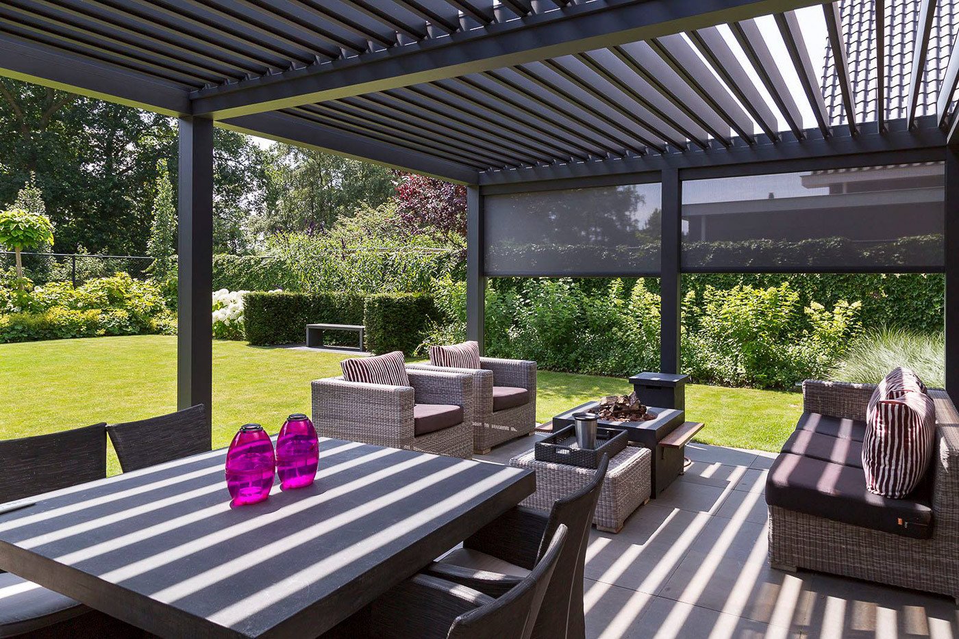 Modern lamellendak terrasoverkapping met comfortabele zithoek en tuinzicht in Sittard-Geleen.
