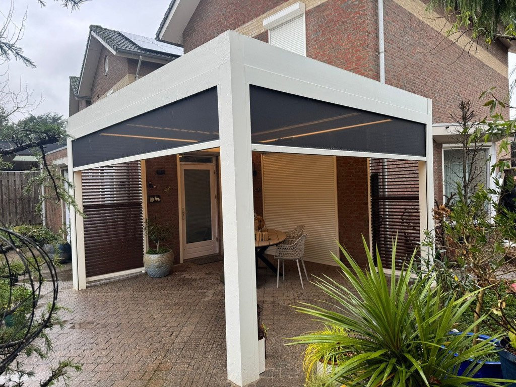 Moderne witte terrasoverkapping aan huis met screens en schutters, dit is een veranda met alle luxe afgewerkt.