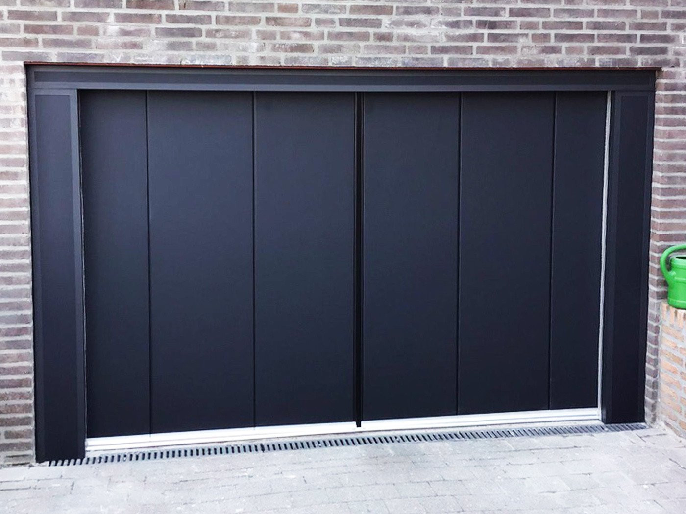 Zijwaartse sectionaaldeur in modern zwart design met stijlvolle afwerking.