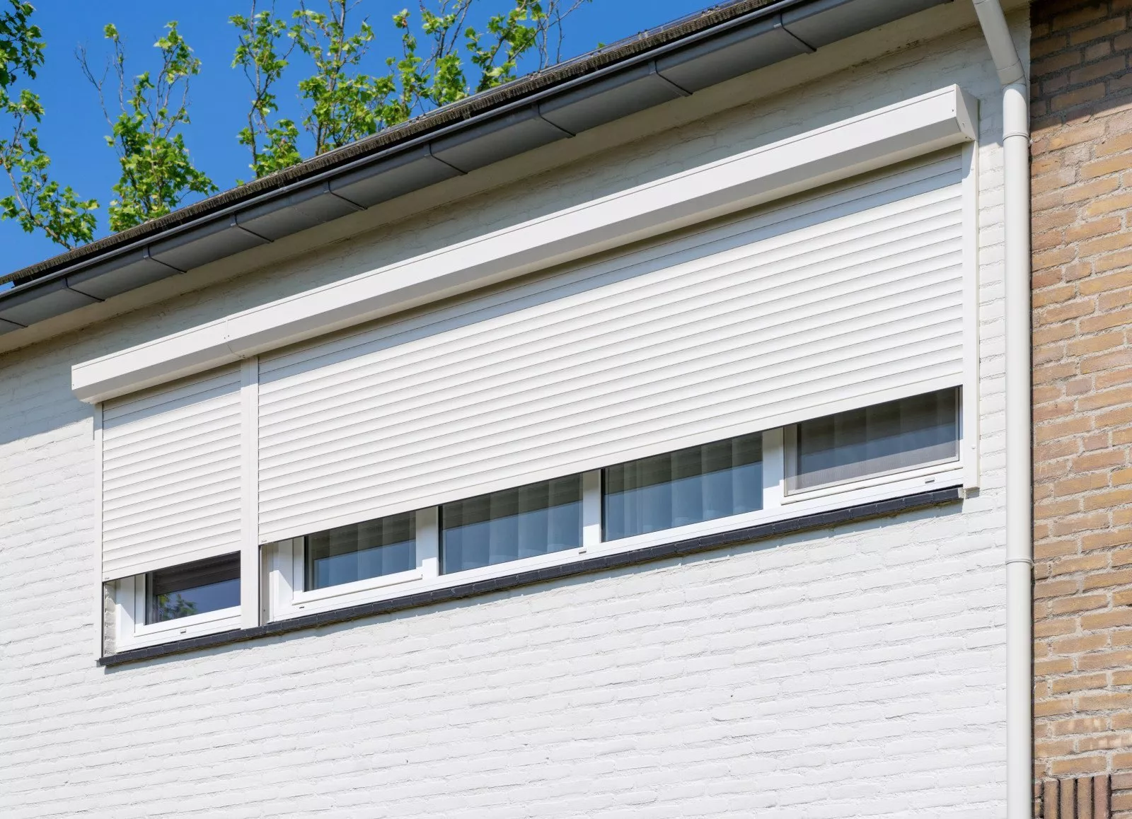 Manually operated roller shutters with white slats on the upper floor in Sittard-Geleen, Limburg
