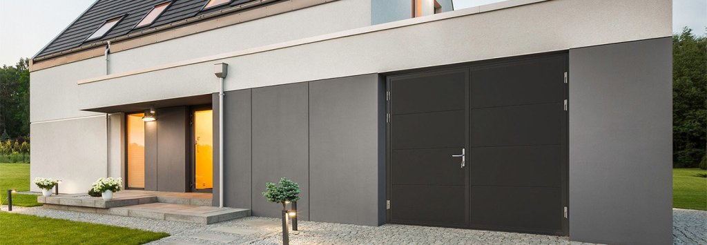 Moderne openslaande garagepoort met strakke lijnen en een antracietkleurige afwerking, passend bij een eigentijdse woning.