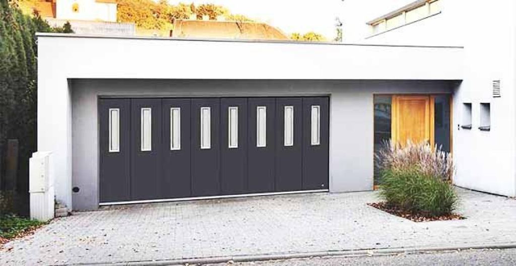 Moderne zijwaartse sectionaaldeur in een eigentijdse garage met verticale glazen zichtvensters.