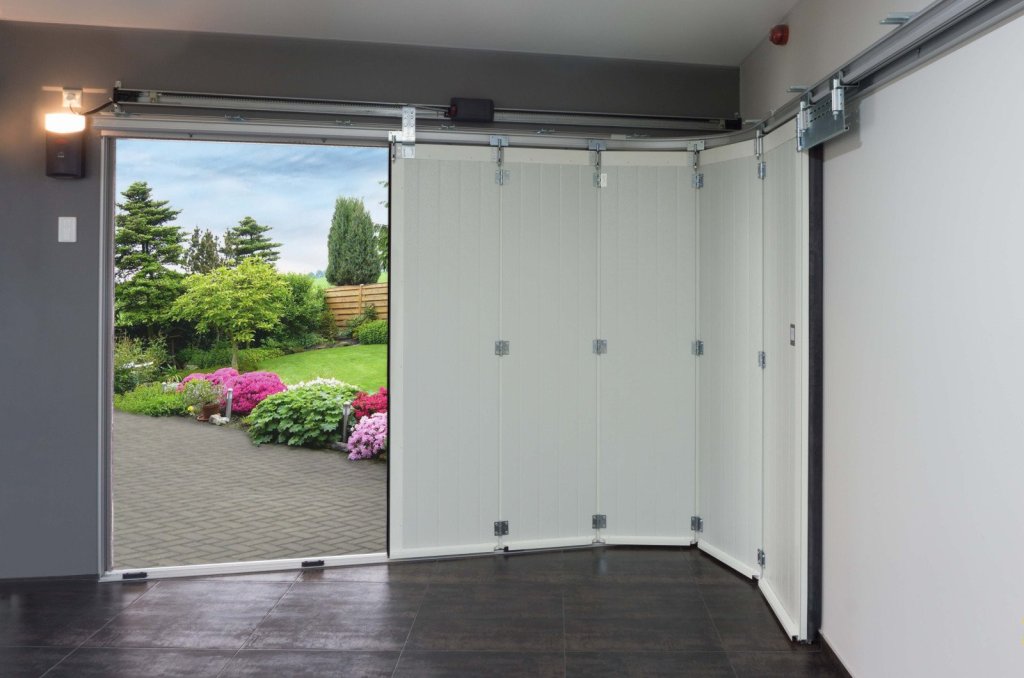 Elegante zijwaartse sectionaaldeur met een moderne afwerking, geopend naar een groene tuin vol bloemen.