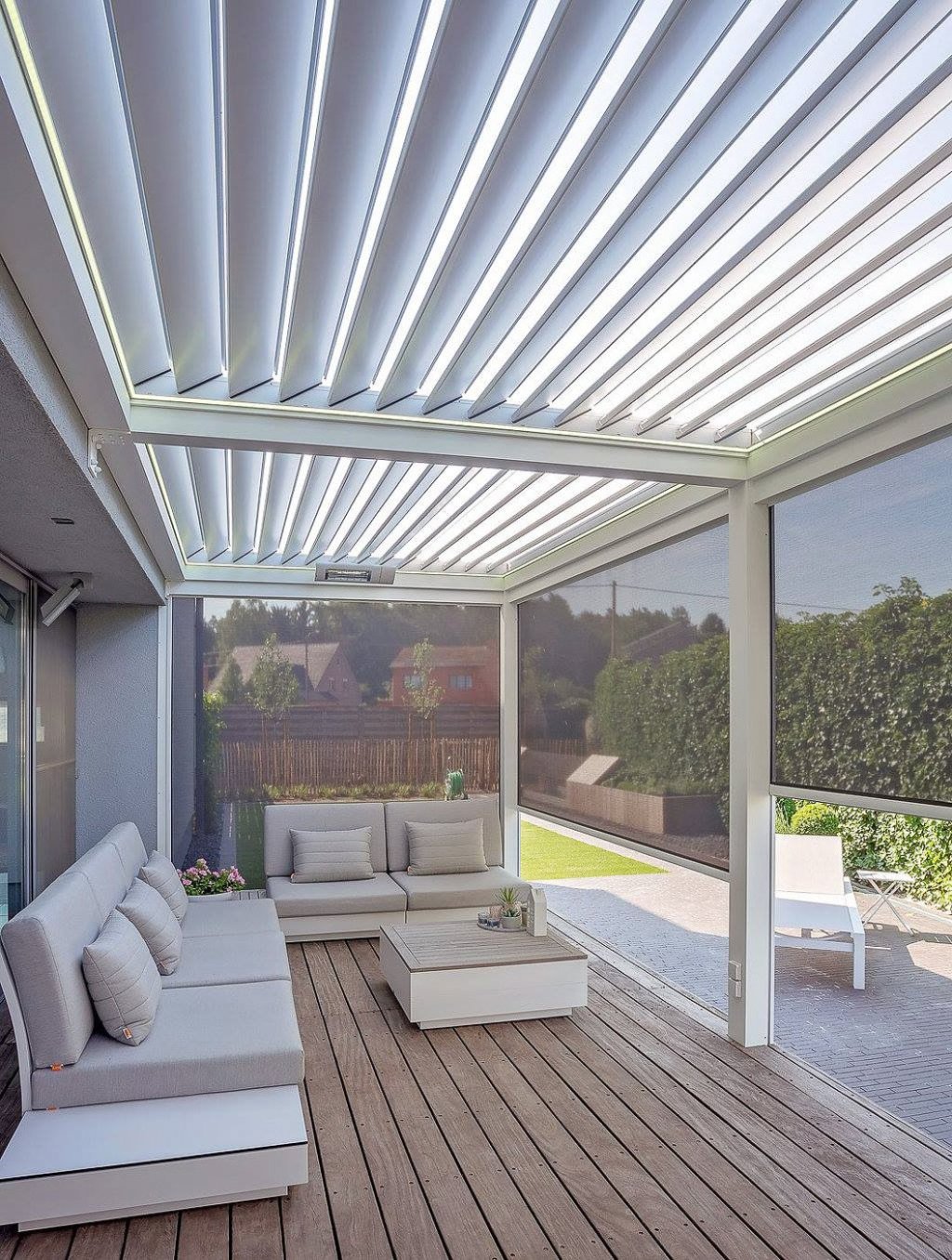 Luxe Lamellendak voor Perfecte Buitenbeleving in Sittard - Geleen Limburg. Lamellendak terrasoverkapping met moderne meubels en houten vloer, ideaal voor buitenontspanning.