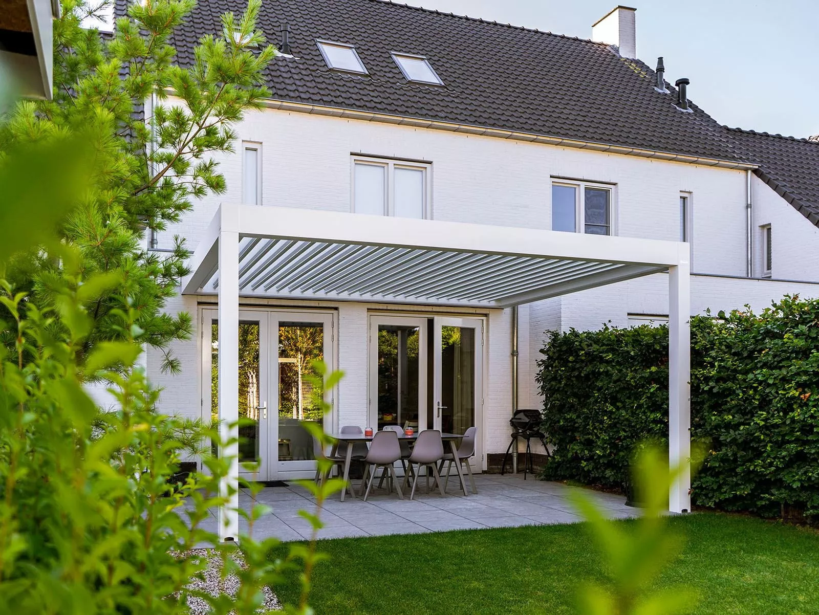 Louvred roof on a white veranda attached to the house, ideal for outdoor use, installed at a modern home in Sittard.