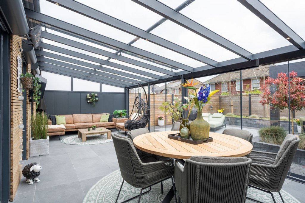 Veranda mit Glasschiebew&auml;nden, Seitenkeil und Aluminiumwand, ideal f&uuml;r N&auml;he zum Garten und gem&uuml;tliche Stunden das ganze Jahr &uuml;ber.
