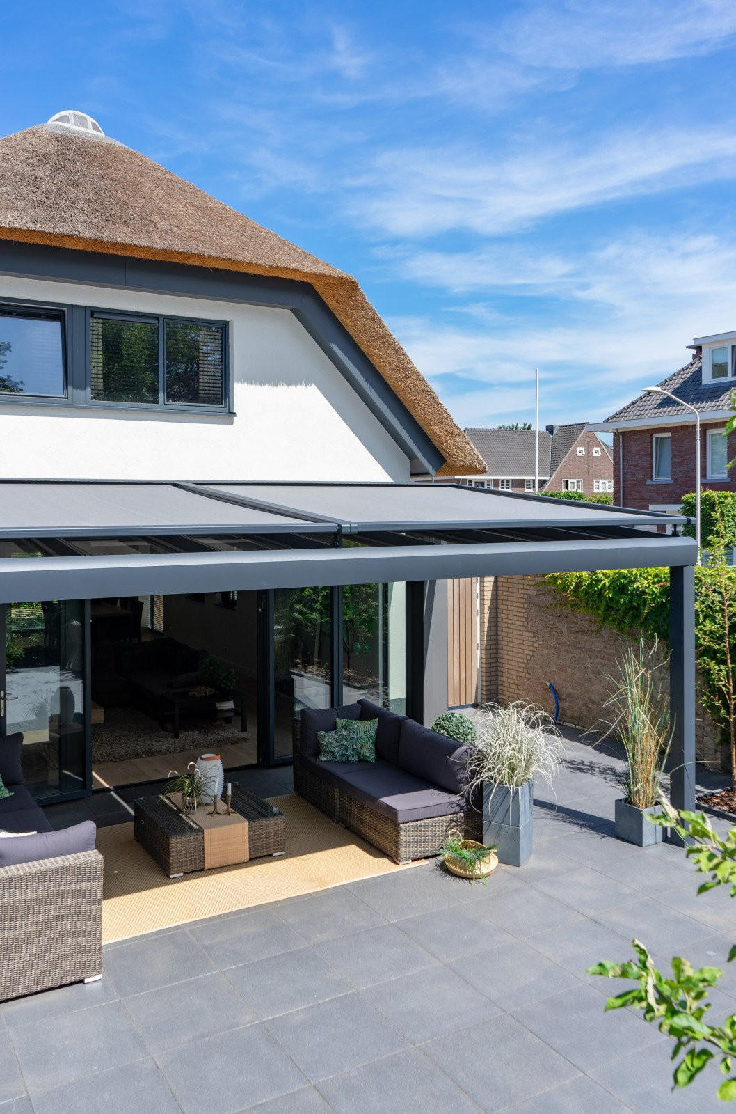 Terrasoverkapping aan huis met veranda zonwering om uw hoofd koel te houden. Moderne terrasoverkapping aan huis met een strakke terrras, voorzien van veranda zonwering.