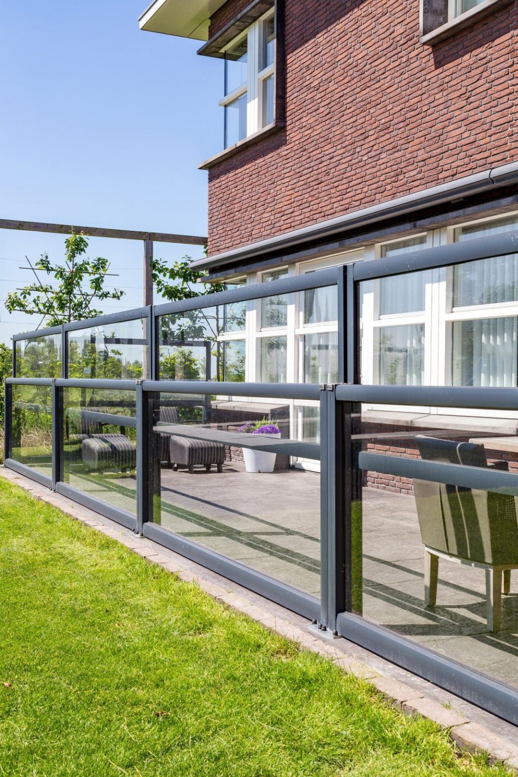 Glass windscreens, perfect for sheltering the patio while staying in touch with the garden.