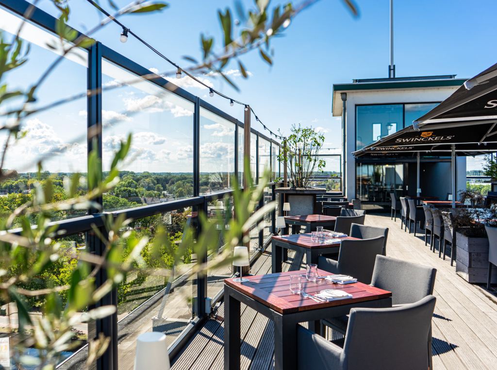 Modern glass windscreen from Renoco on a roof terrace with a view, giving shelter while keeping the view open.