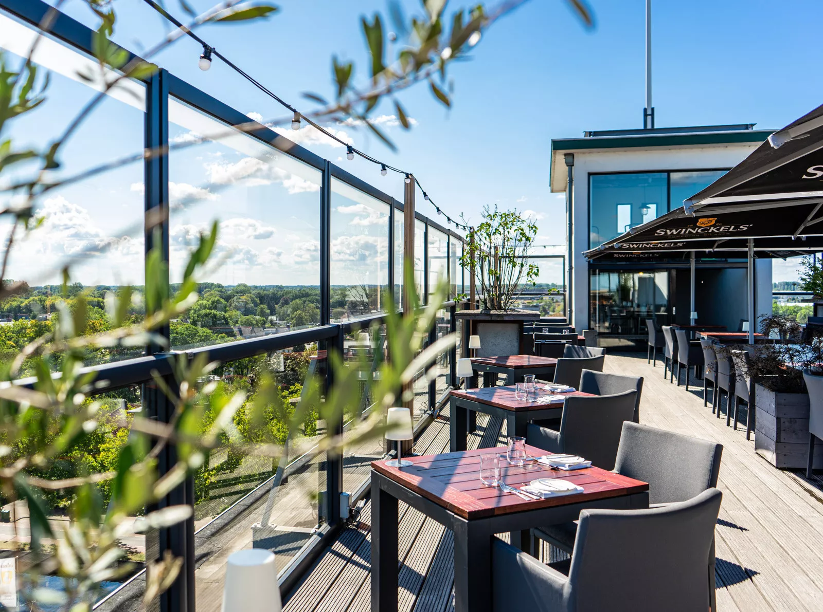 Modern glass windscreen from Renoco on a roof terrace with a view, giving shelter while keeping the view open.
