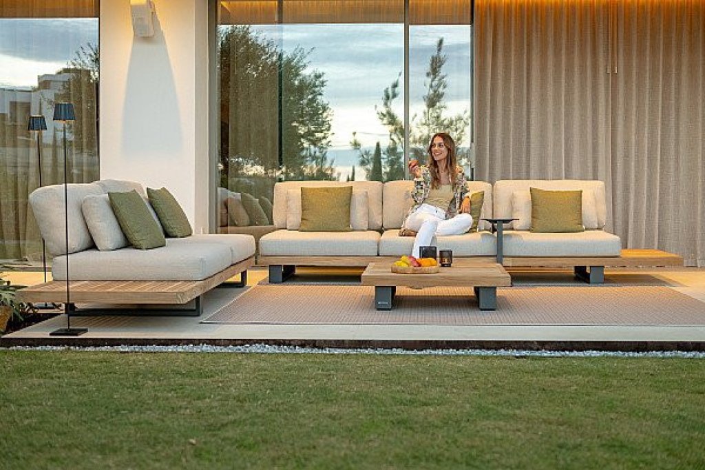 Luxe tuinmeubelen met comfortabele loungebank en bijzettafel op een modern terras.