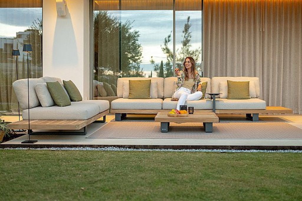 Luxuri&ouml;se Gartenm&ouml;bel mit bequemem Loungesofa und Beistelltisch auf einer modernen Terrasse.