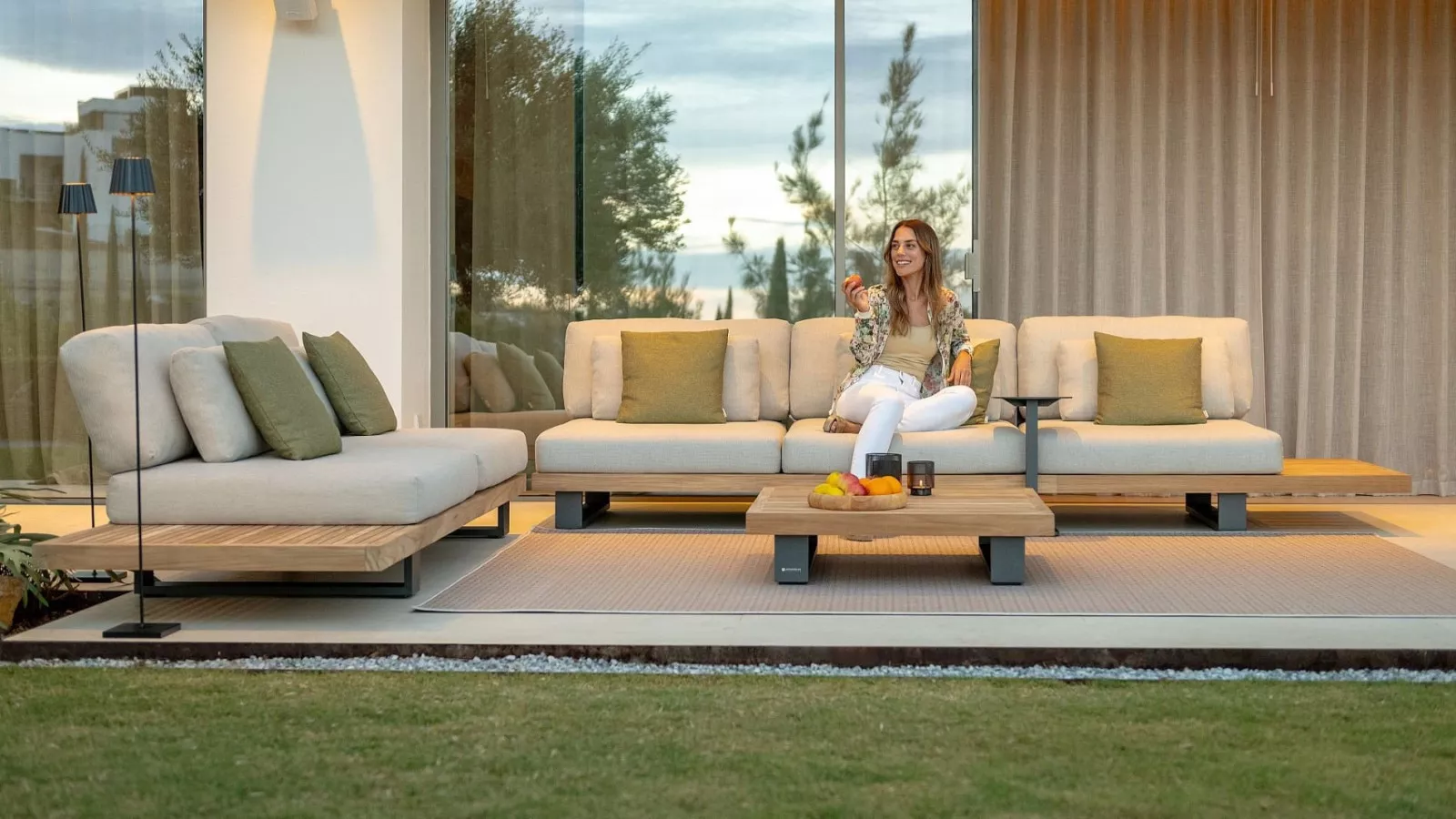 Moderne Gartenmöbel mit einem bequemen Sofa und Couchtisch auf einer Terrasse.