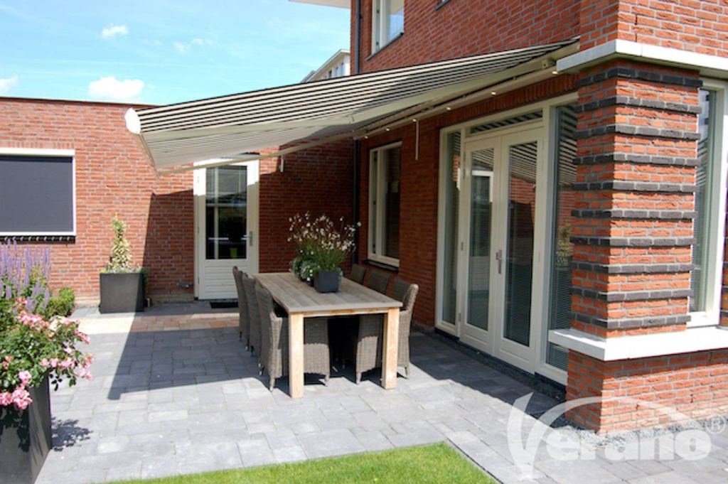 Striped Verano folding-arm awning providing shade on a sunny patio, expertly installed by Renoco.