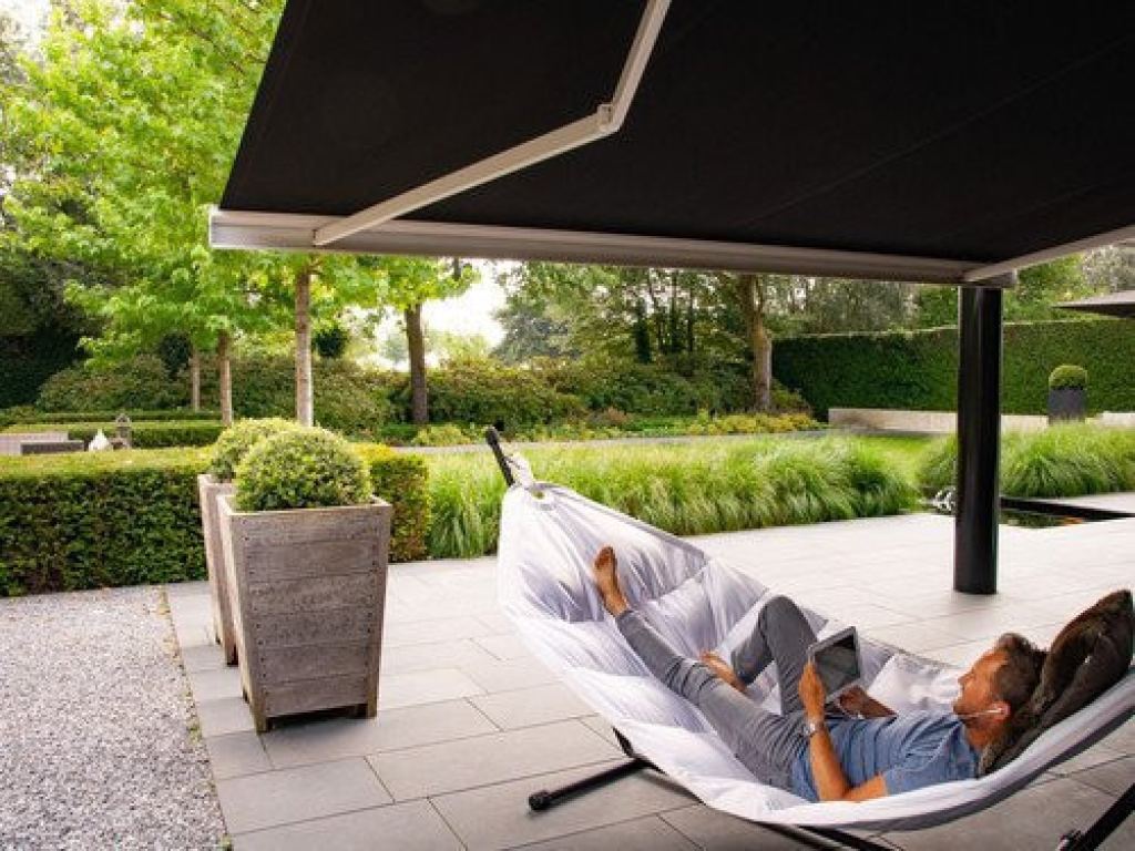 Folding-arm awning in a modern garden, providing shade for a relaxing moment on the patio in Sittard-Geleen, Limburg.