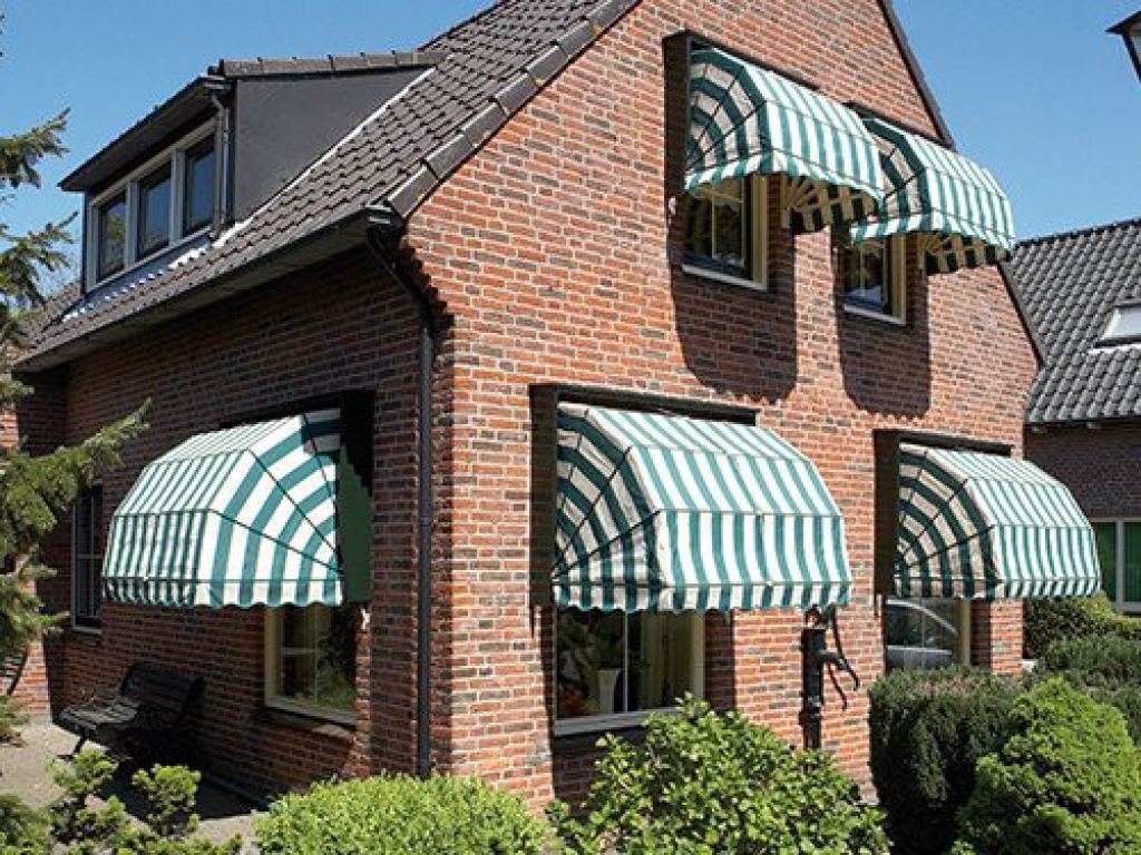 Green-and-white striped Dutch canopies as external sun shading on a house with a garden.