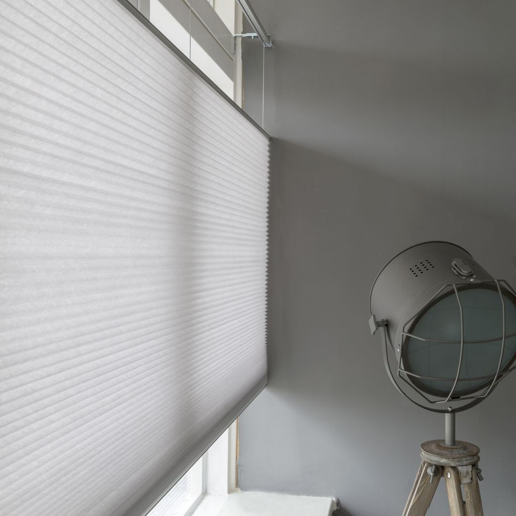Light-coloured pleated blinds regulating the incoming light elegantly and efficiently in Sittard-Geleen, Limburg.