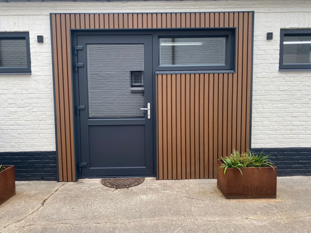 Tuindeur met glas met composiet gevelbekleding aan een witte gevel Sittard - Geleen Limburg.
