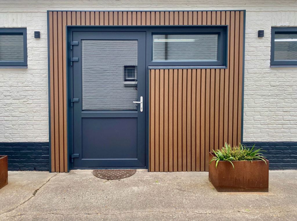 A sleek door and frames combine beautifully with the WEO composite wall cladding from Renoco.