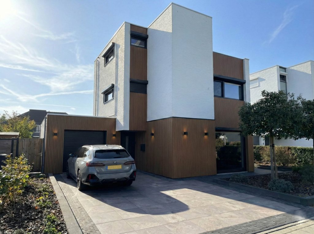 Sleek, modern fa&ccedil;ade with Fiberdeck composite cladding and handsome black roller shutters, perfect for a modern home in Sittard-Geleen.