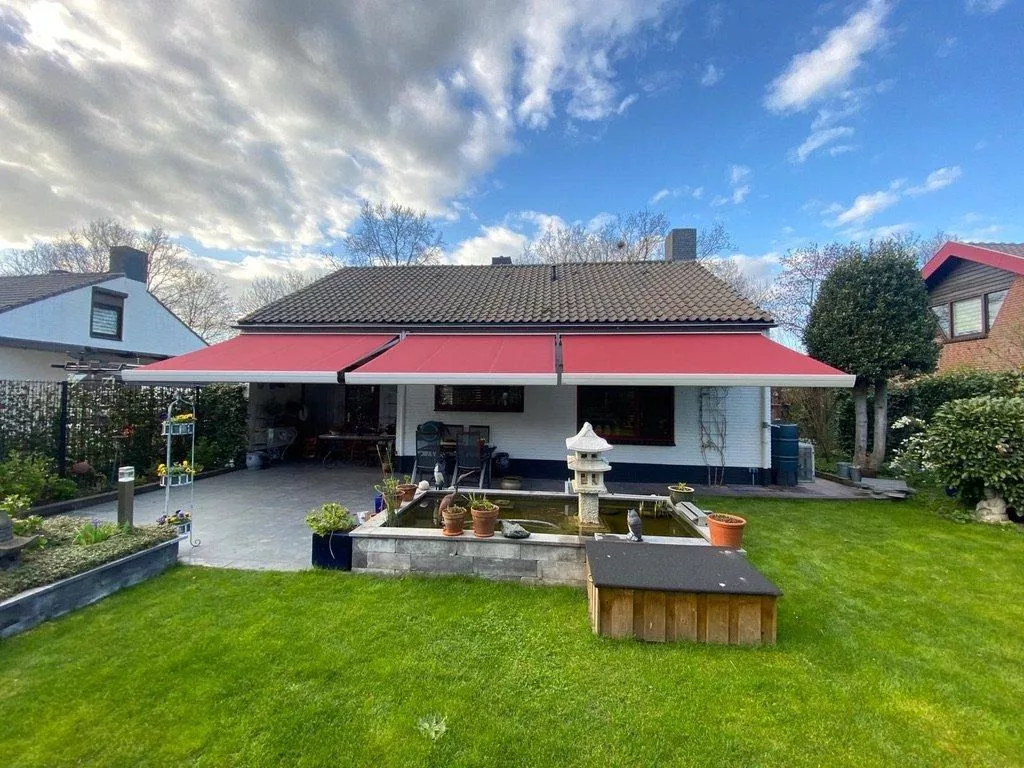 Red awnings from Renoco provide shade and comfort in the garden