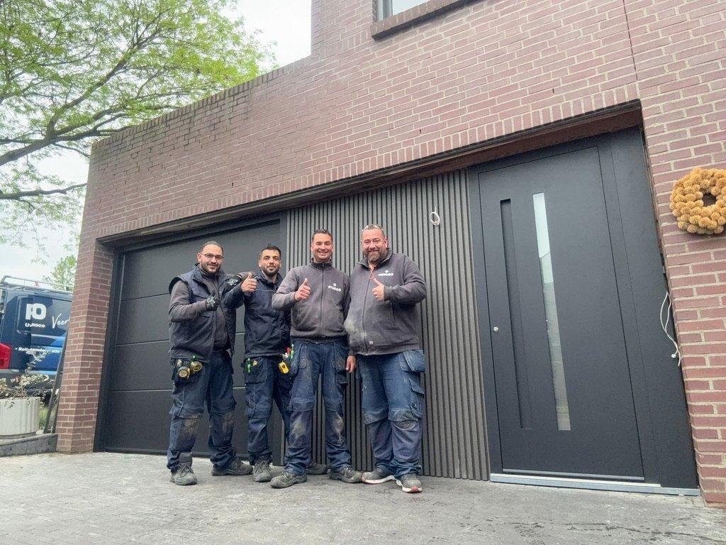 Renoco monteurs na montage van een moderne garagepoort en voordeur op maat.