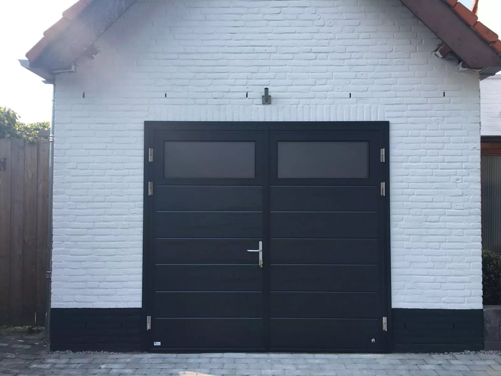 Schwarzes Flügeltor mit Glaselementen und moderner Optik in Sittard-Geleen und Limburg