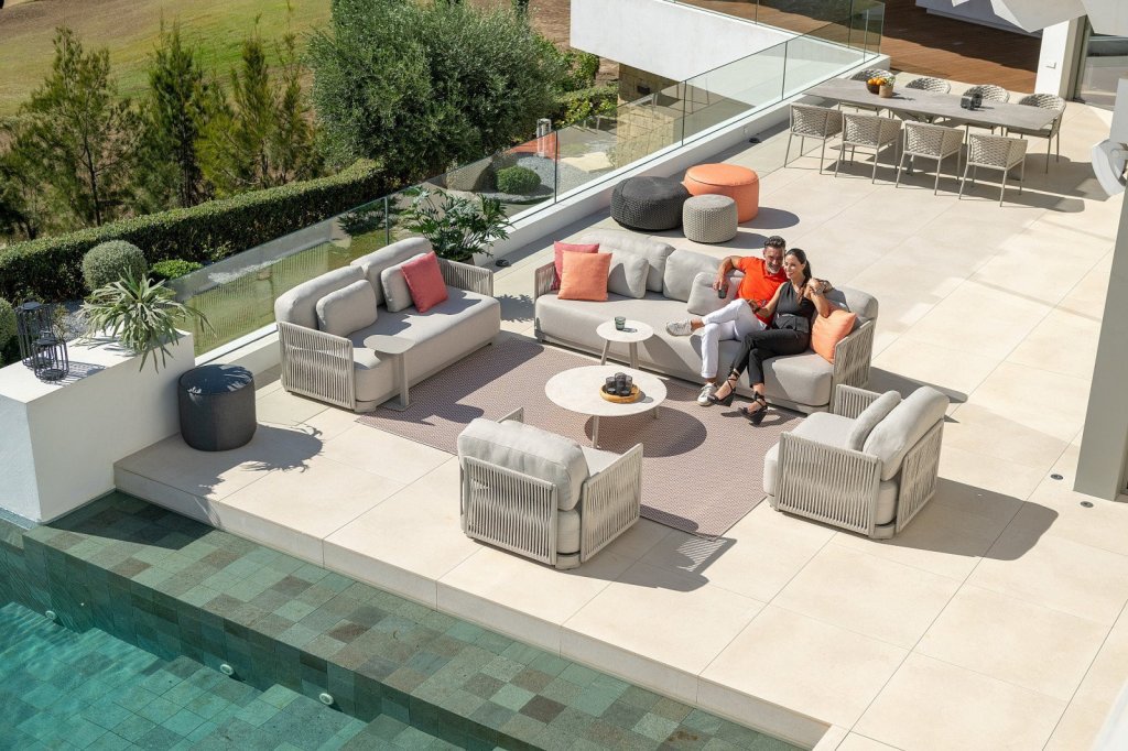 Luxe tuinmeubelen voor uw perfecte terraservaring!. Modern tuinmeubelen met een loungehoek en kleurrijke kussens op een terras bij het zwembad.