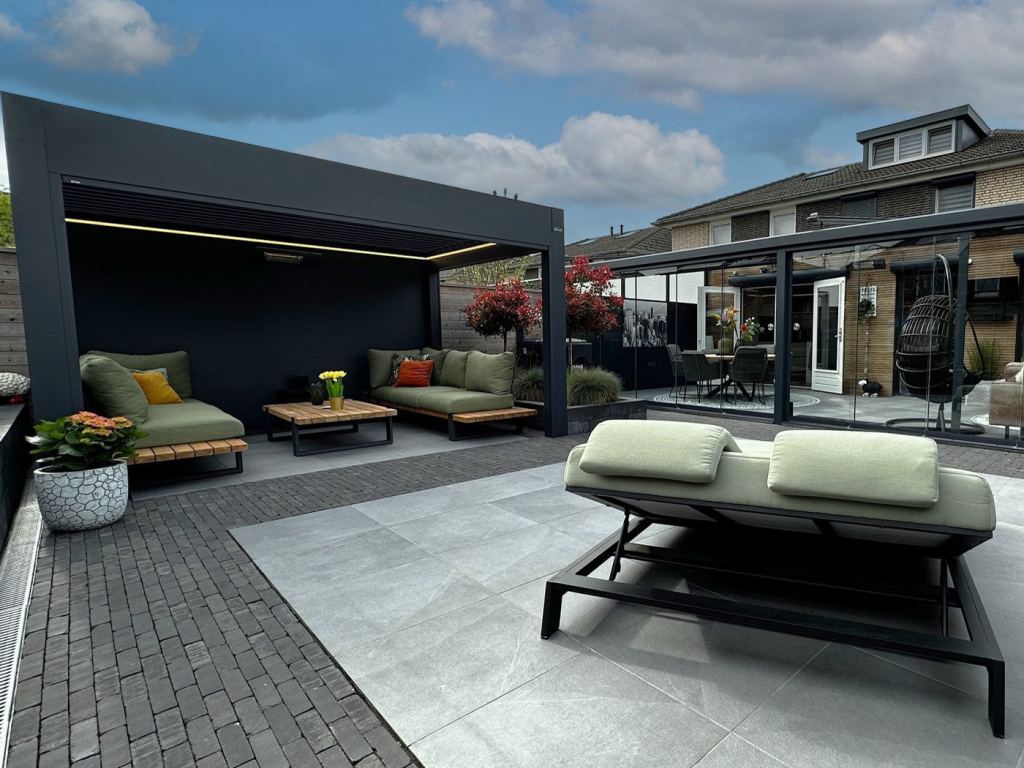 Terrassen&uuml;berdachung und Veranda mit Sitzecke und gr&uuml;ner Lounge-Garnitur in einem modernen Garten in Sittard-Geleen Limburg.