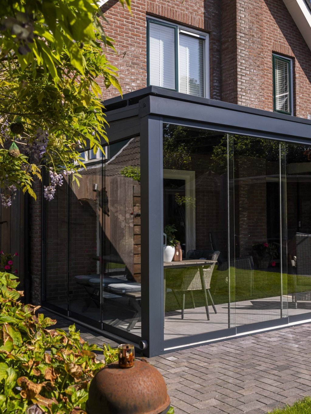 Heerlijk genieten van uw eigen overkapping? Renoco monteert in Sittard - Geleen en Limburg!. Stijlvolle vrijstaande overkapping met glazen wanden, perfect voor een moderne woning in de tuin.