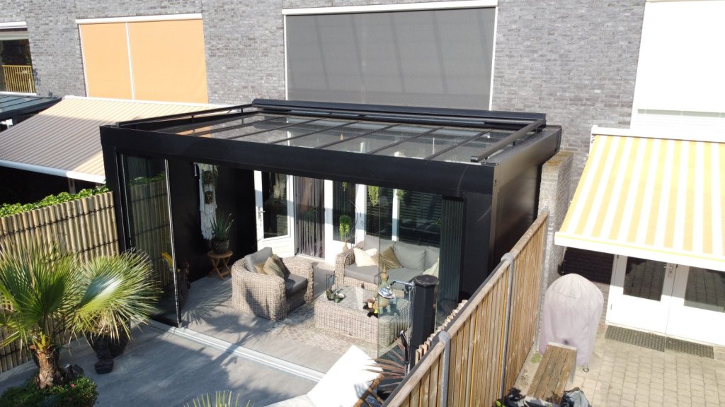 Prachtige veranda voor ultiem comfort en stijl in Sittard - Geleen Limburg. Moderne verandamet aluminium constructie en glazen wanden, ingericht met comfortabele meubels en planten.