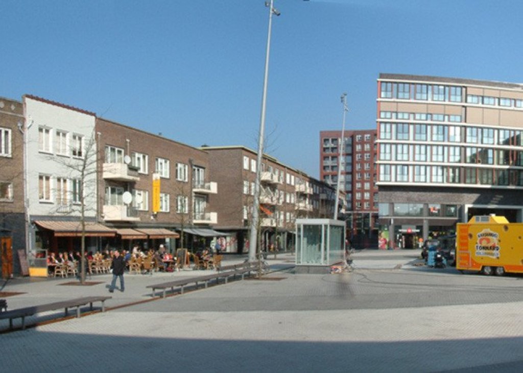 Een rustige stadsplein met zonnige terrassen in Geleen.