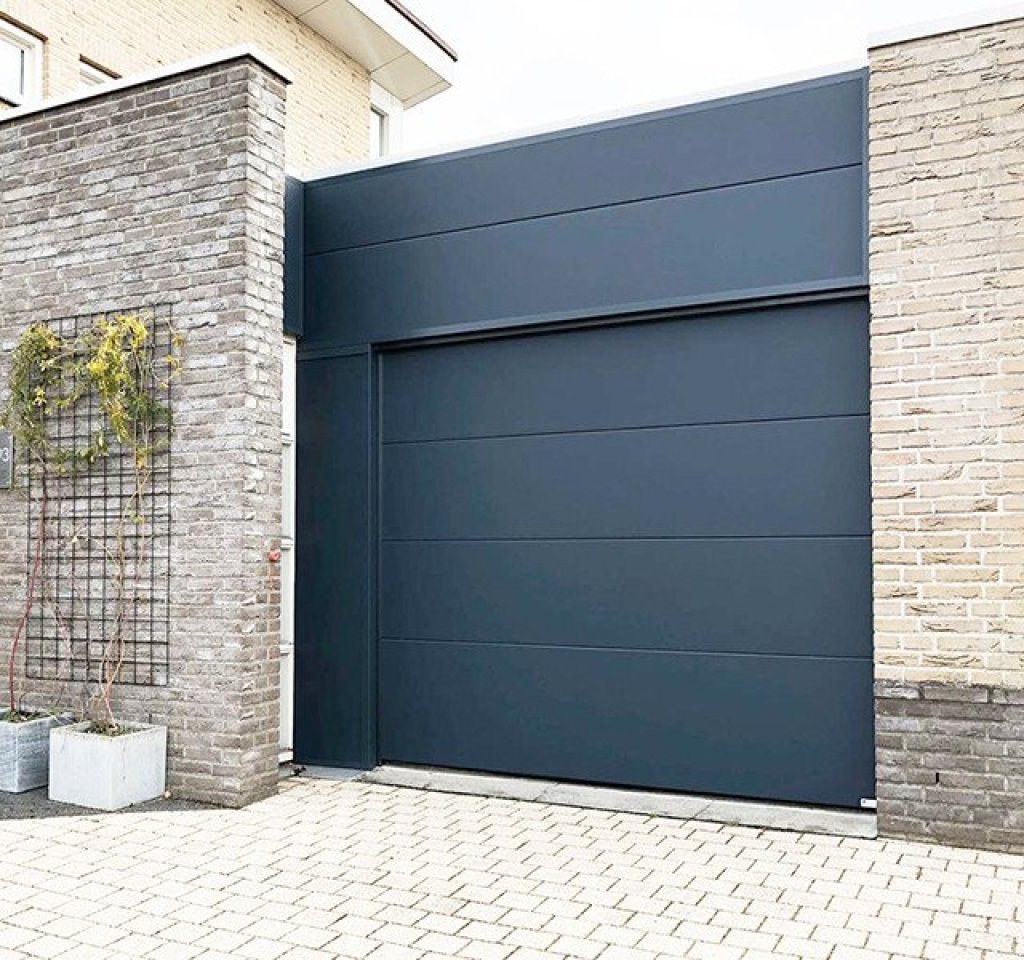 Stijlvolle sectionaaldeur met bijpassende gevelbekleding. Stijlvolle sectionaaldeur met bijpassende gevelbekleding in zelfde stijl voor uniforme uitstraling.