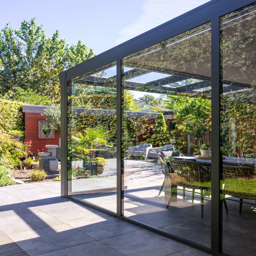 Glazen schuifwanden in Sittard - Geleen Limburg. Veranda met glazen schuifwanden, perfect voor tuincontact en gezelligheid het hele jaar door.