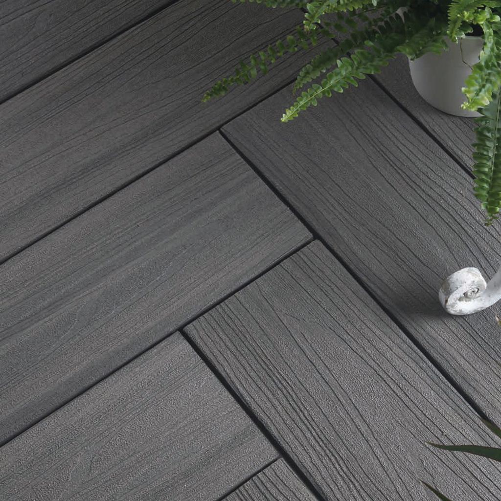 Sleek dark-grey composite decking with a natural wood look and a plant in a white pot.