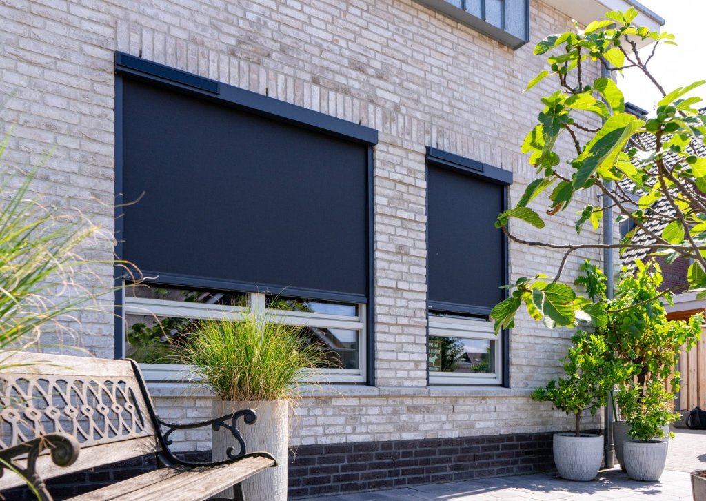 Moderne woning voorzien van windvaste screens en ritzscreens met solar bediening die warmte buiten houden en zorgen voor privacy en energiebesparing.