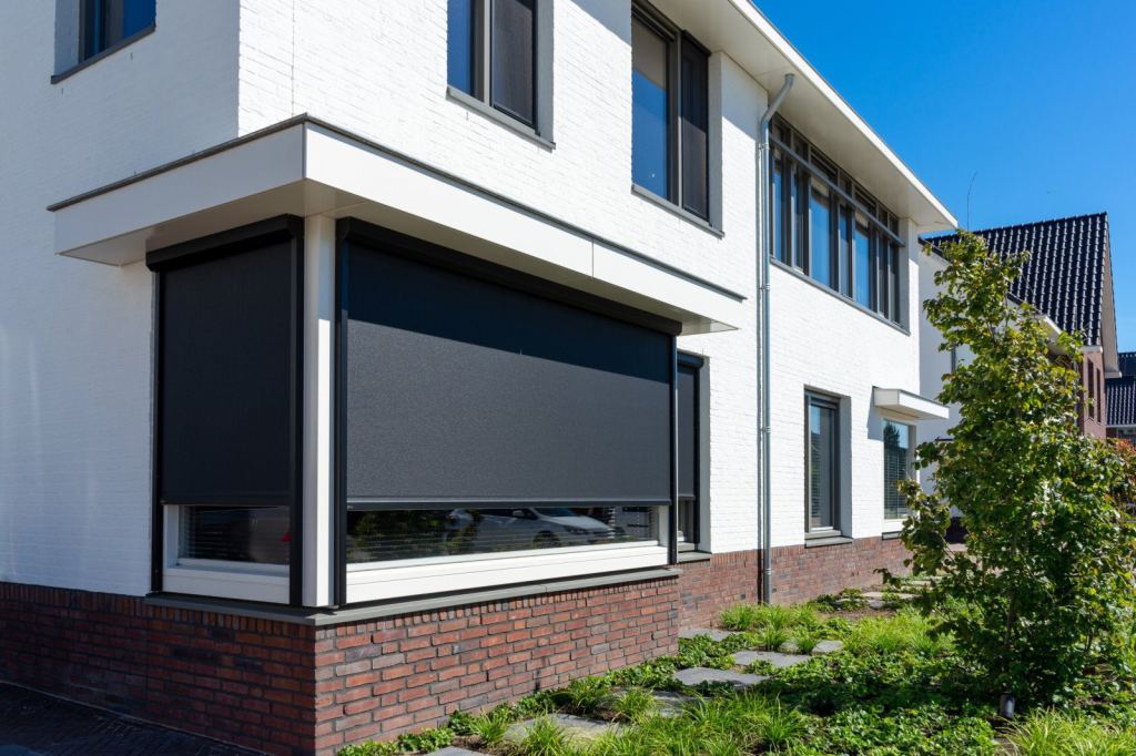 Moderne ritsscreens in zwart voor een strakke woning, zorgen voor schaduw en privacy.