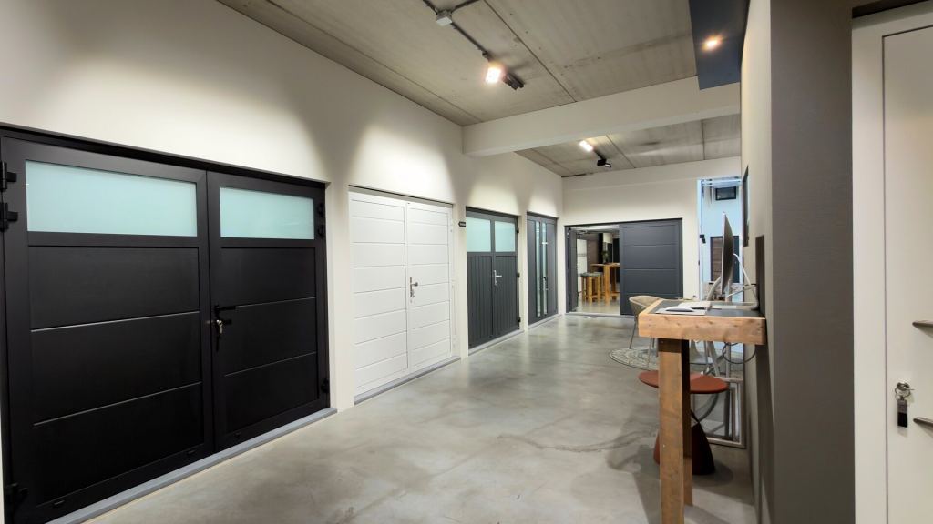 Side-hinged garage doors in black, white and anthracite in the Renoco showroom.
