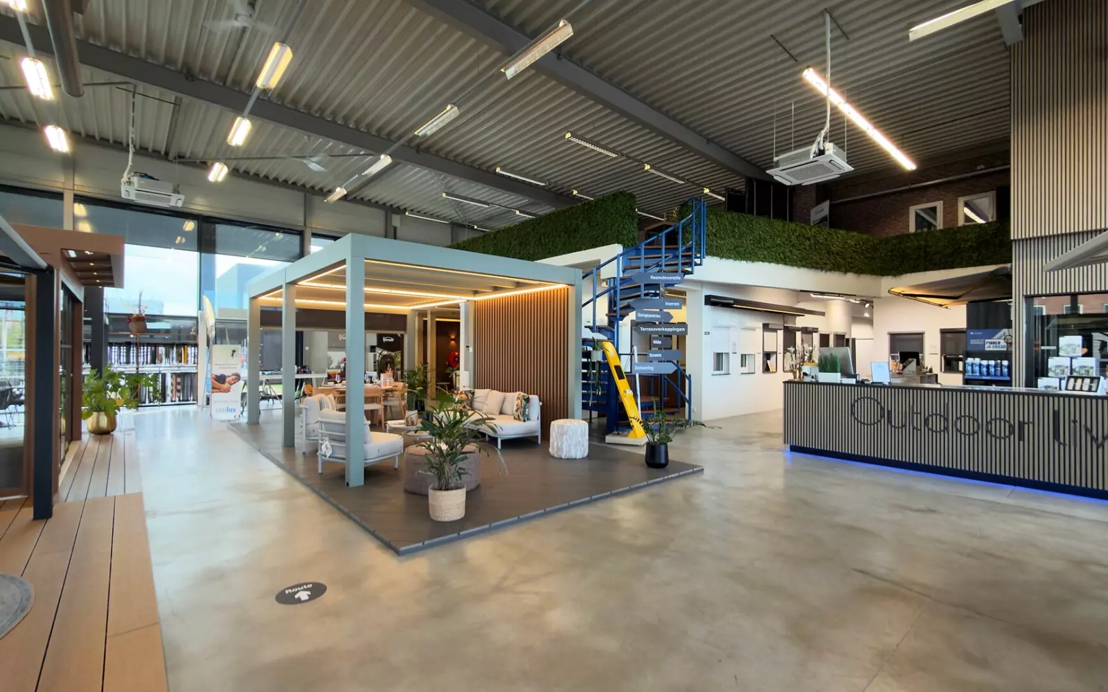 De entreehal van de Renoco showroom in Sittard, met een overkapping, een loungeset en de balie