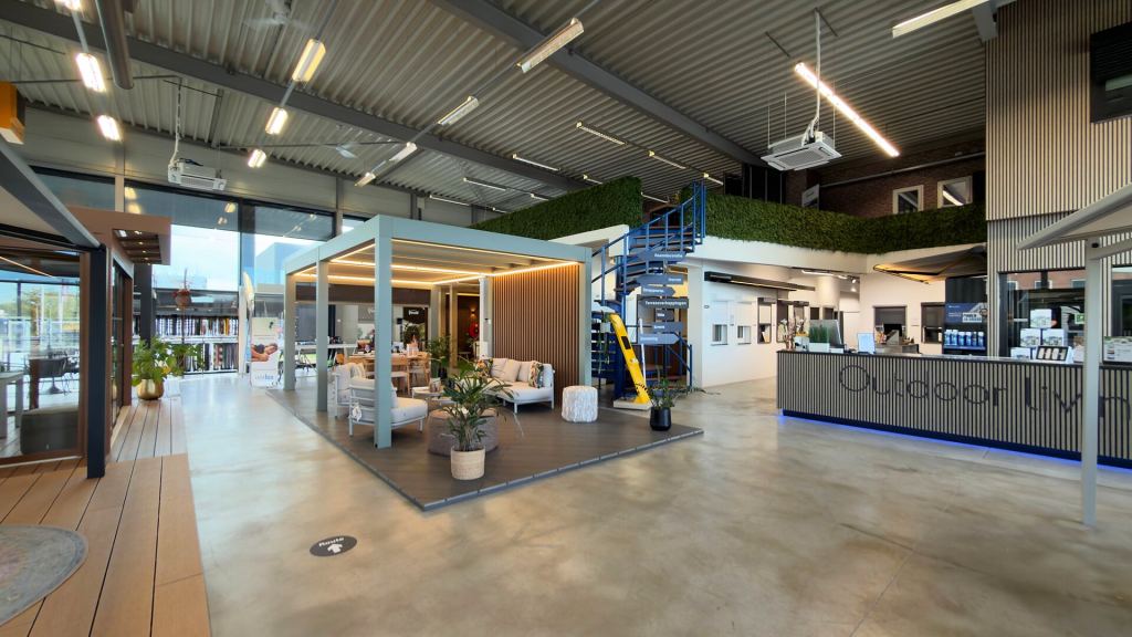 De entreehal van de Renoco showroom in Sittard, met een overkapping, een loungeset en de balie.