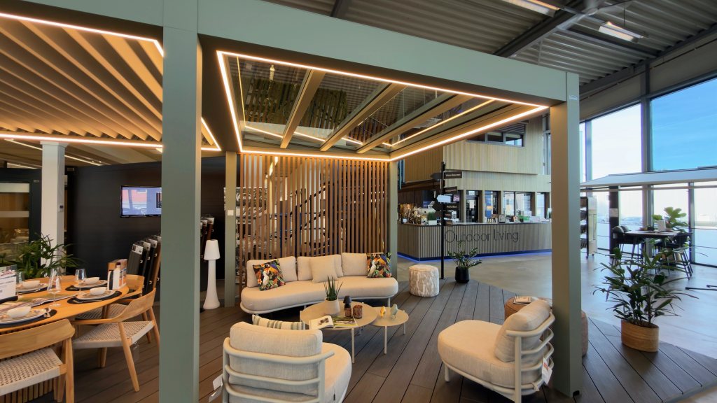 Louvred roof with LED lighting and a lounge set by the Outdoor Living desk in the Renoco showroom in Sittard.