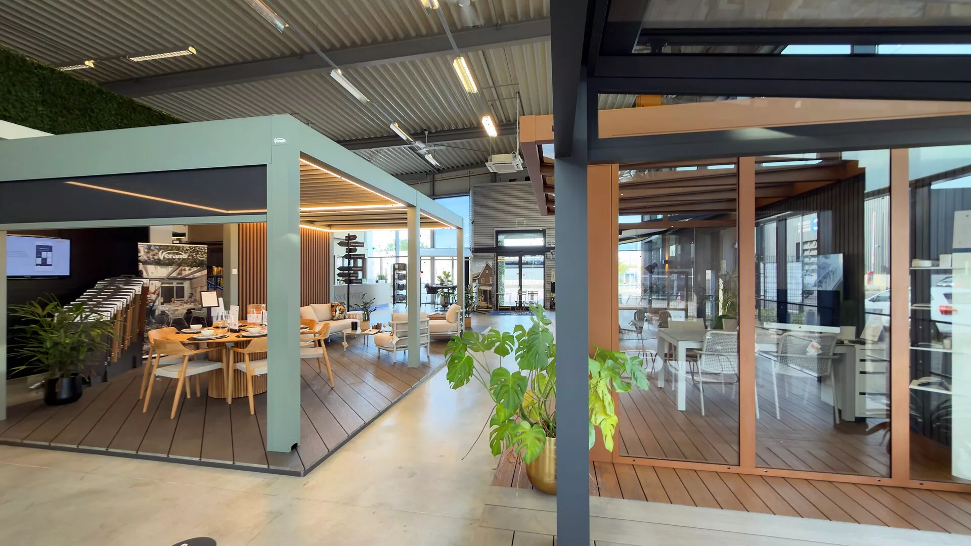 Two patio covers with a dining table and a lounge set side by side in the Renoco showroom