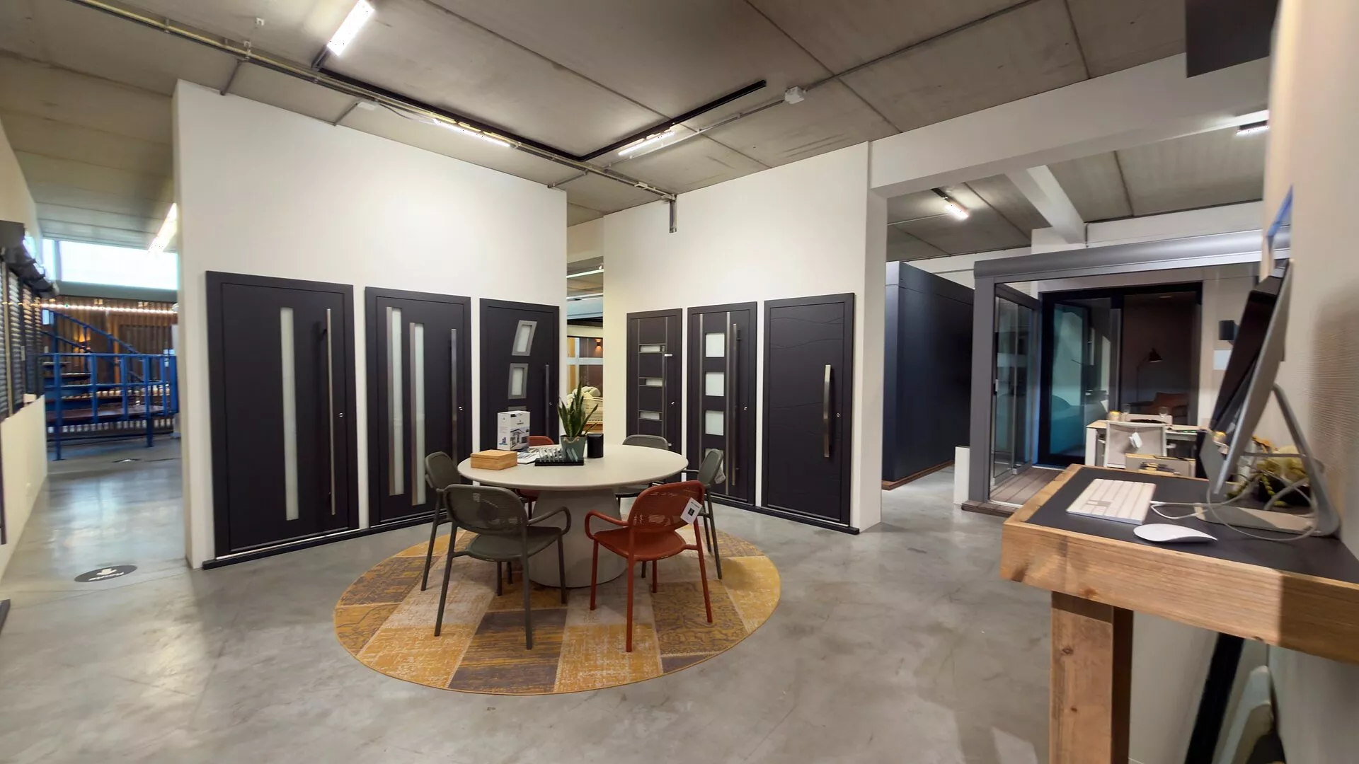 Front doors in various models around a seating area in the Renoco showroom