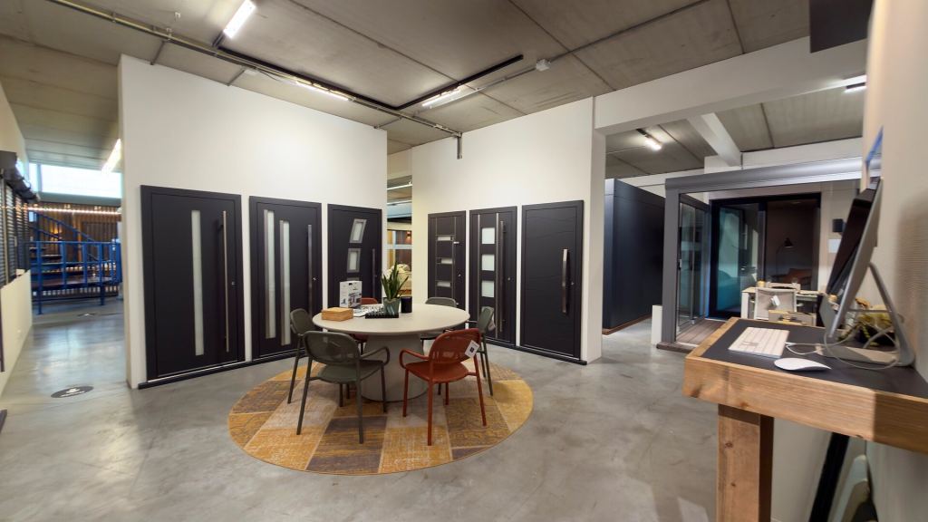 Front doors in various models around a seating area in the Renoco showroom.