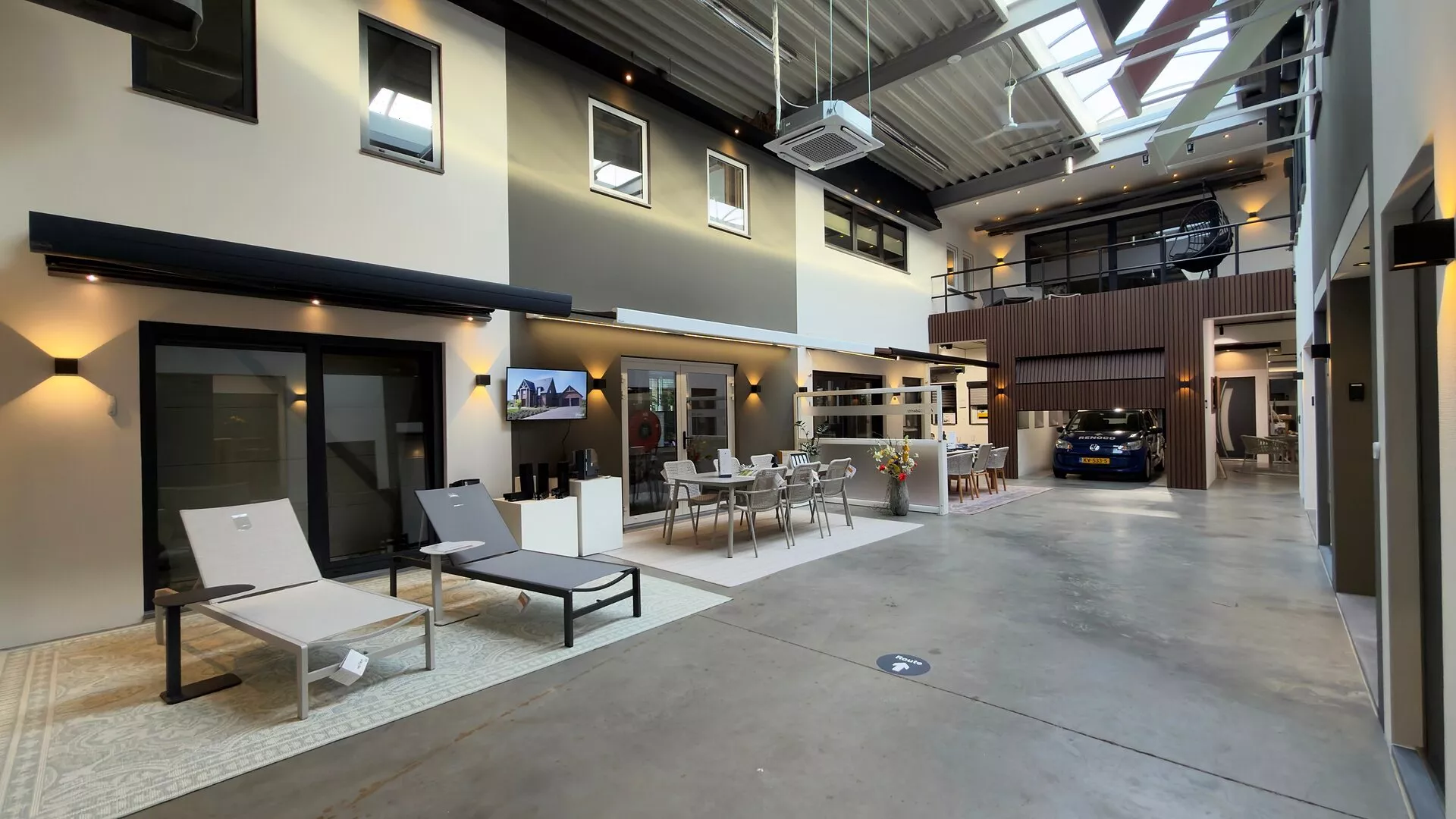 Awning above a sliding patio door with sun loungers and a garden furniture set in the Renoco showroom