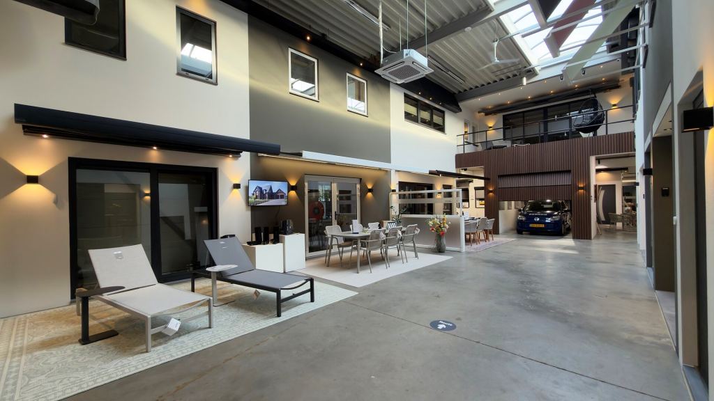 Awning above a sliding patio door with sun loungers and a garden furniture set in the Renoco showroom.