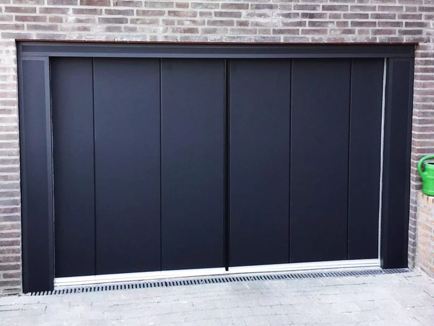 Side-sliding sectional door in a modern black design with a stylish finish.