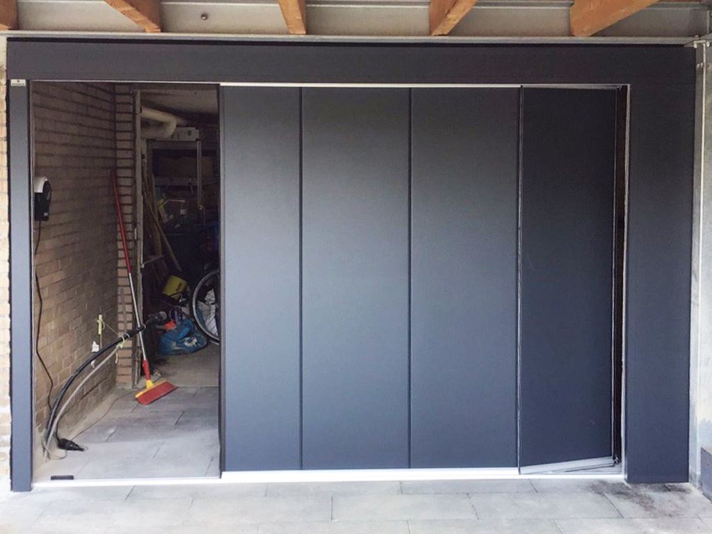Black side-sliding sectional door with a sleek finish in a garage setting.