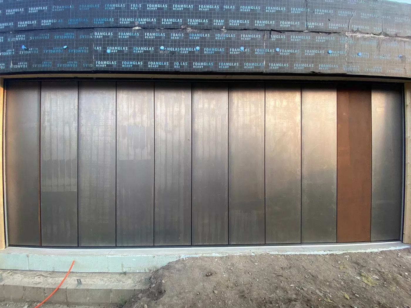 Side-sliding sectional door in various finishes for modern homes, perfect for garages.